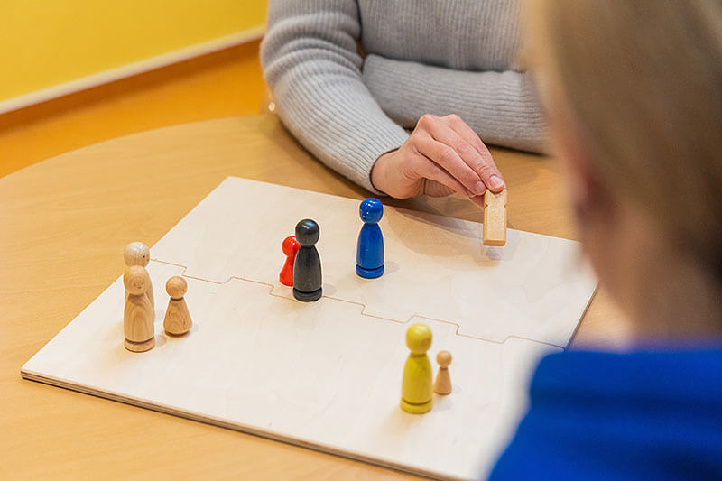 Familienaufstellung an einem Brett mit Spielfiguren
